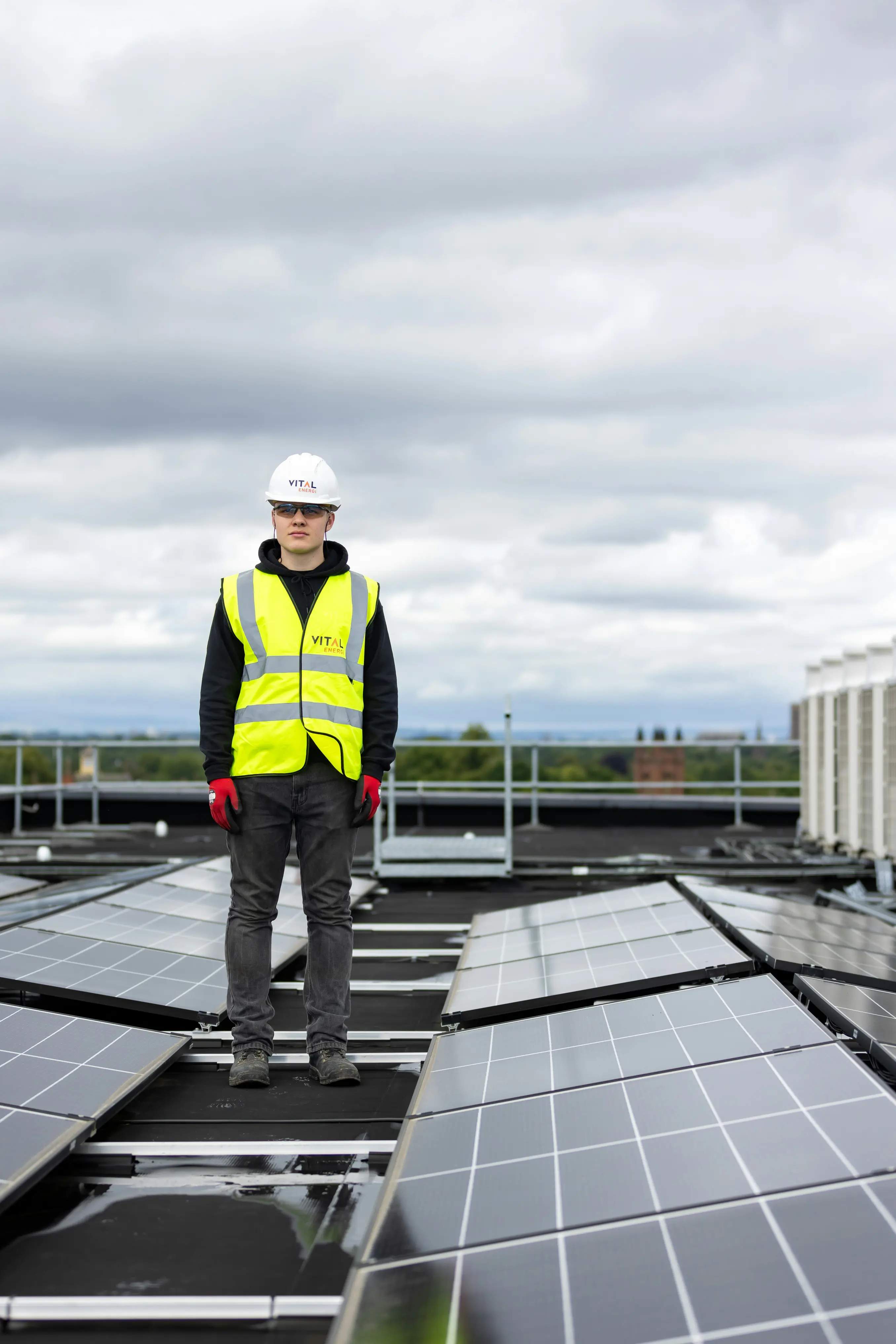 Technician installing solar panels on a rooftop array